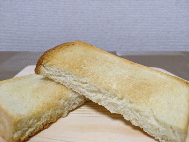 パン屋つきほし製パン所のつきほし食パンを焼いたトースト1枚を半分に切って板の上に置いている写真