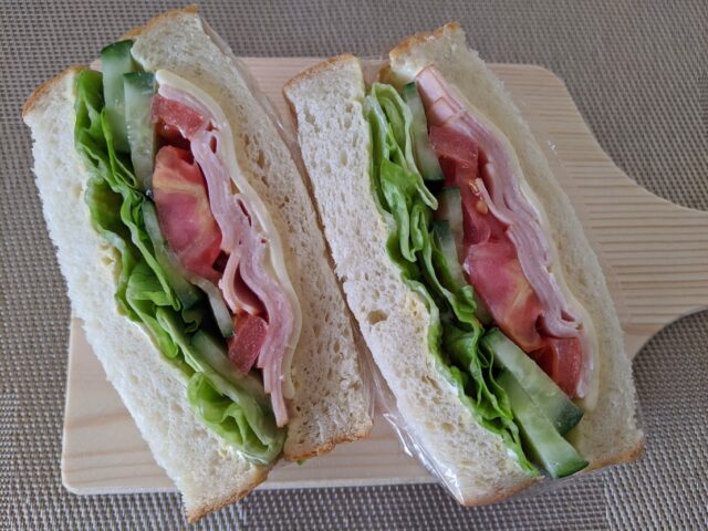 パン屋サンプラスの食パンで作ったハムチーズサンドイッチを半分に切った写真