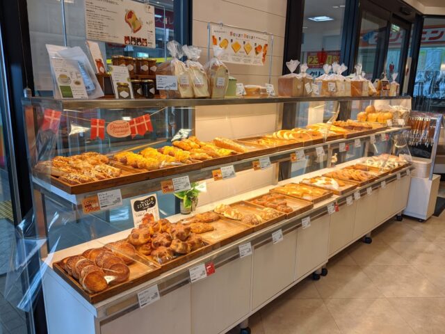 パン屋トランドール南福岡駅店の店内入ってすぐ左側にたくさんのパンが棚に並んでいる写真