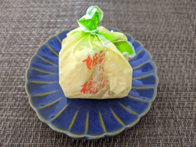 和菓子店如水庵の姫橘1個をお皿の上に置いている写真