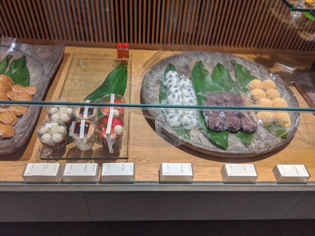 和菓子店鈴懸本店菓舗のおはぎや大福やぜんざいがガラスケースに並んでいる写真