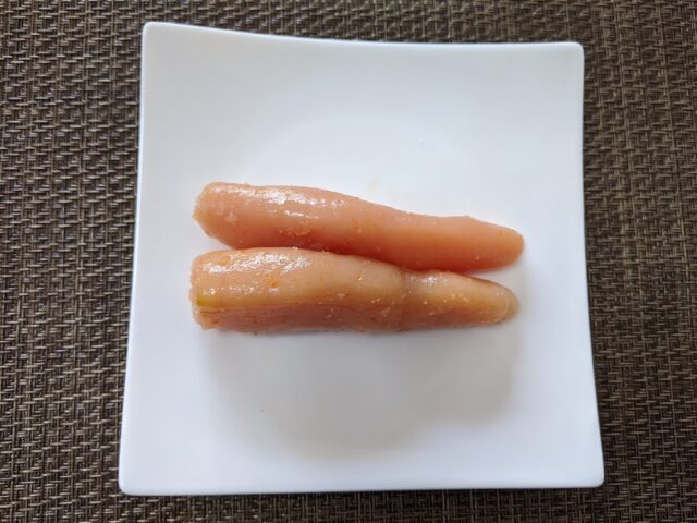 島本のオリジナル辛子明太子一腹をお皿にのせてテーブルに置いている写真