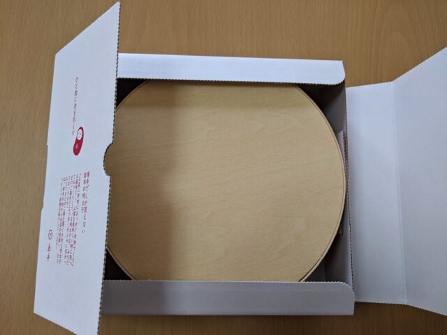 島本のオリジナル辛子明太子が入った白い箱を開けた状態をテーブルに置いている写真
