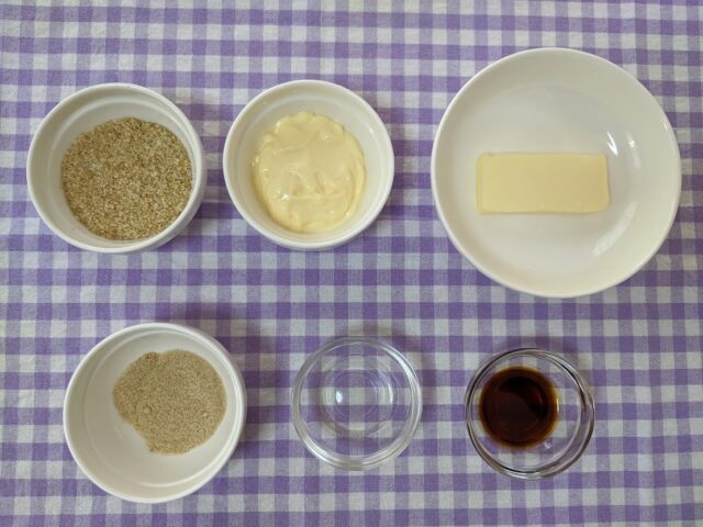 ごぼうサラダとチキンのサンドイッチに使う調味料ですりごまとマヨネーズとバターときび砂糖とお酢としょうゆがテーブルに置いてある写真