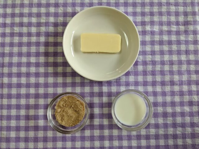 さつまいものサンドイッチに使う調味料の牛乳ときび砂糖と有塩バターをお皿に入れてテーブルに置いている写真