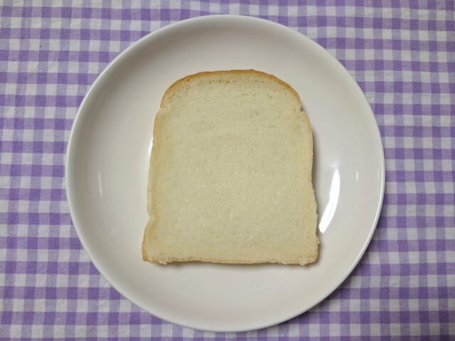 パン屋ベーカリーナサンの食パン1枚をお皿に入れてテーブルに置いている写真