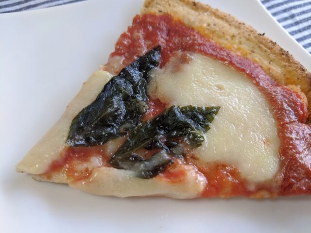 カットしたピザレボの極・マルゲリータのピザ1枚をお皿に入れテーブルに置いている写真
