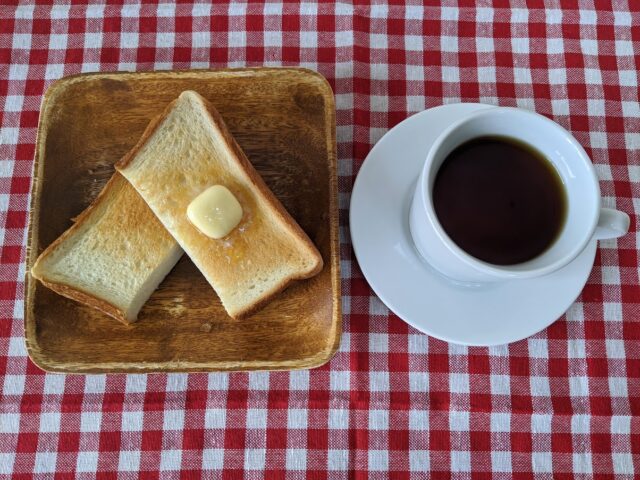 コーヒー豆「キアニャンギ」を使って淹れたコーヒーと自然酵母食パン1枚をトーストしてカットしバターを塗つたものの写真