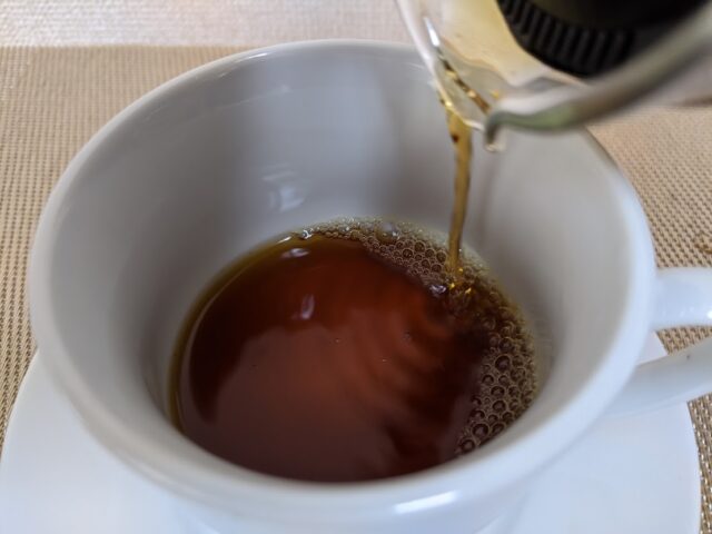 コーヒー豆のキッサブレンドをドリップしたものをコーヒーカップに3/5注いでいる写真