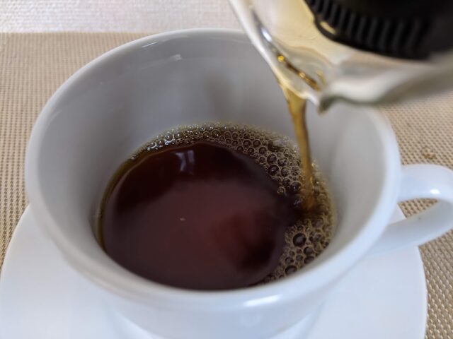 コーヒー豆のキッサブレンドをドリップしたものをコーヒーカップに4/5注いでいる写真