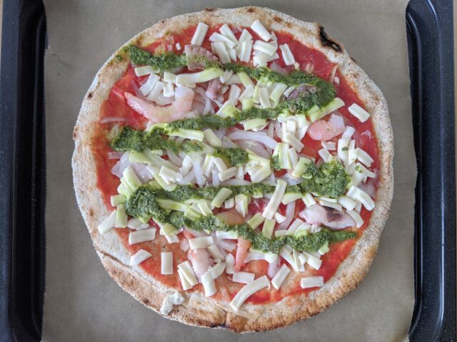 海鮮トマトバジルの冷凍ピザをオーブンプレートに置いている写真