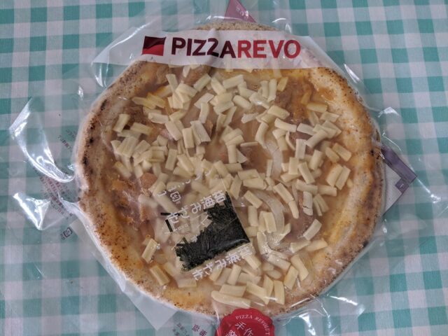 ピザ屋ピザレボの照り焼きチキン冷凍ピザをテーブルに置いている写真
