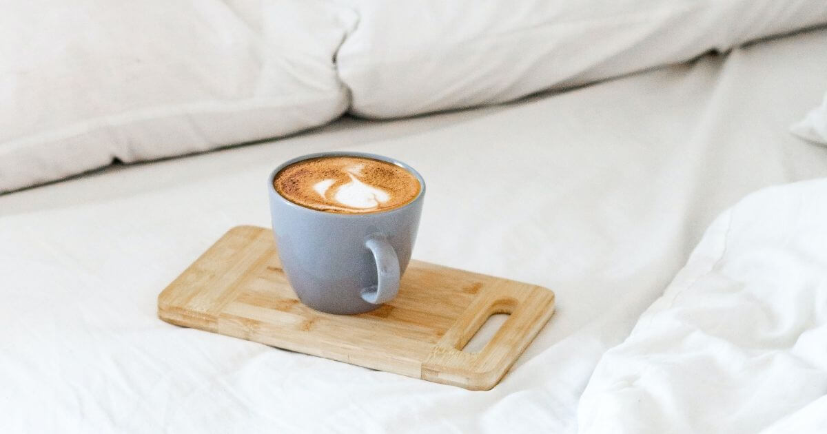 ベッドにコーヒーカップが置いてある画像