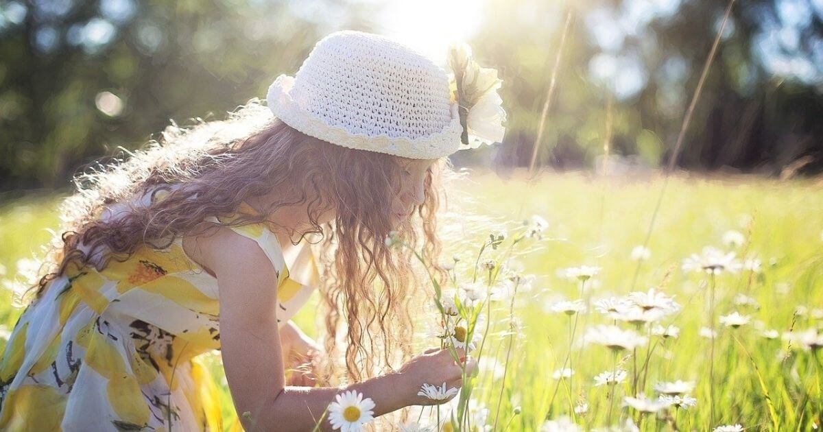 女の子が草花を摘んでいる画像