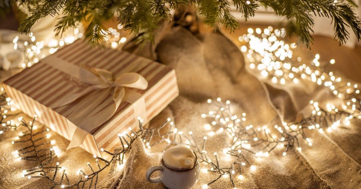 クリスマスツリーの下にプレゼントとカプチーノが置いてある画像