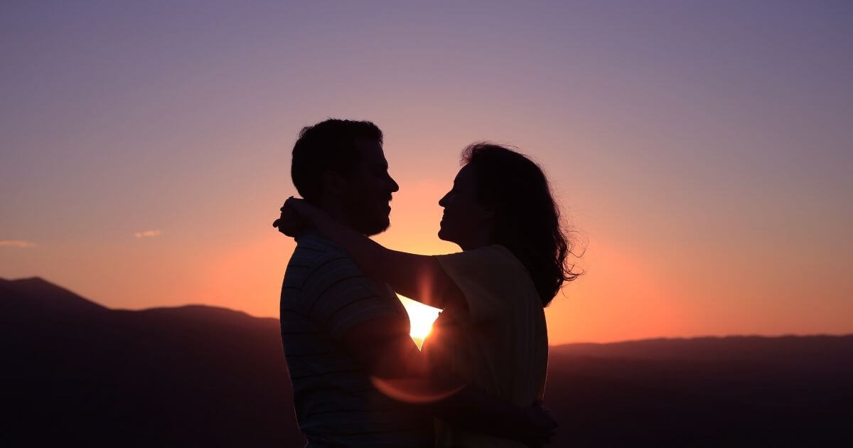 夕日の背景にカップルの画像
