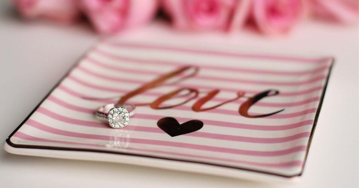 ピンクのLOVEと描かれたお皿にダイヤの指輪が置いてある画像