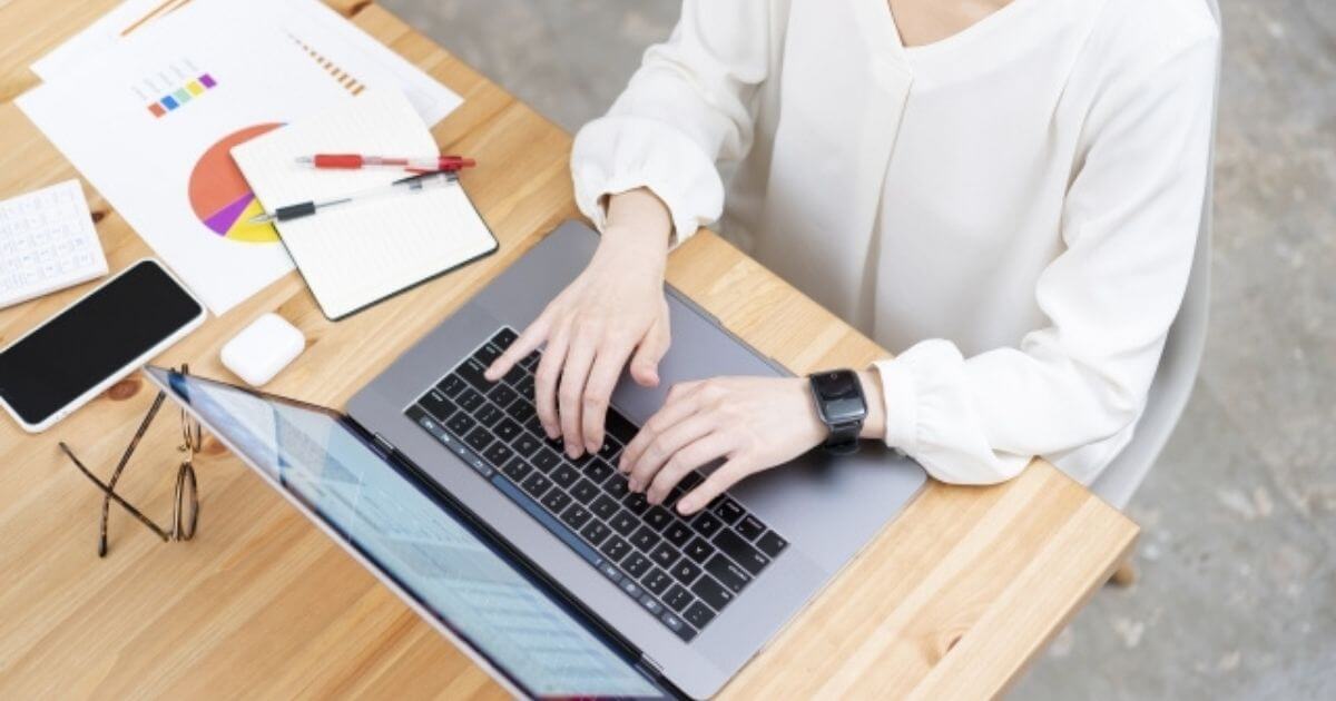女性がパソコンを使い事務仕事をしている画像