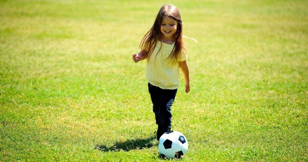 女の子がサッカーボールを蹴っている画像