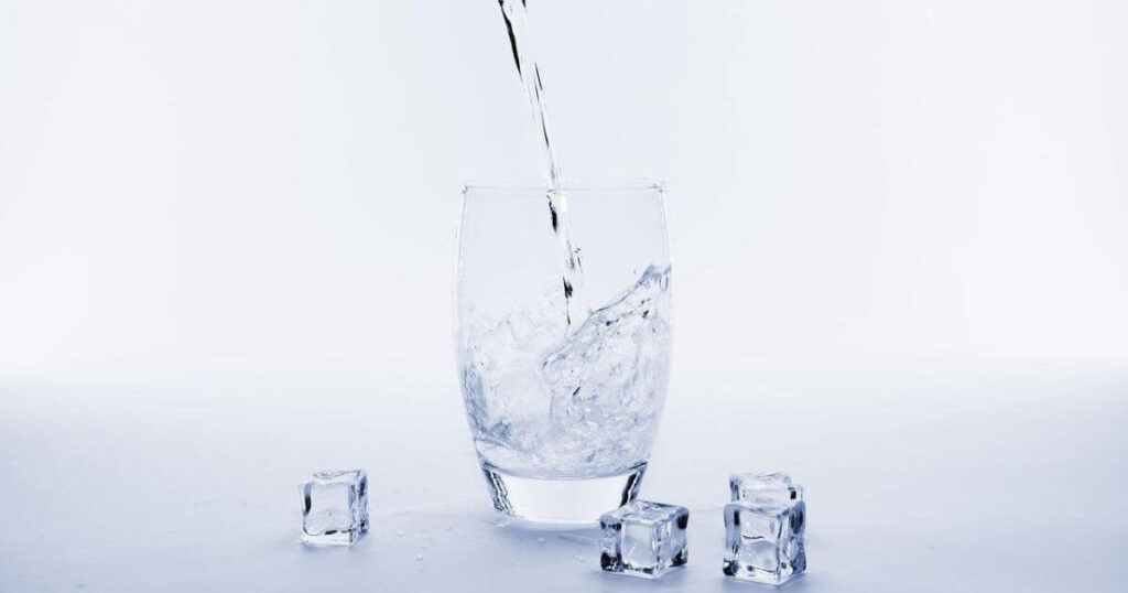 グラスに水を注いでいる画像